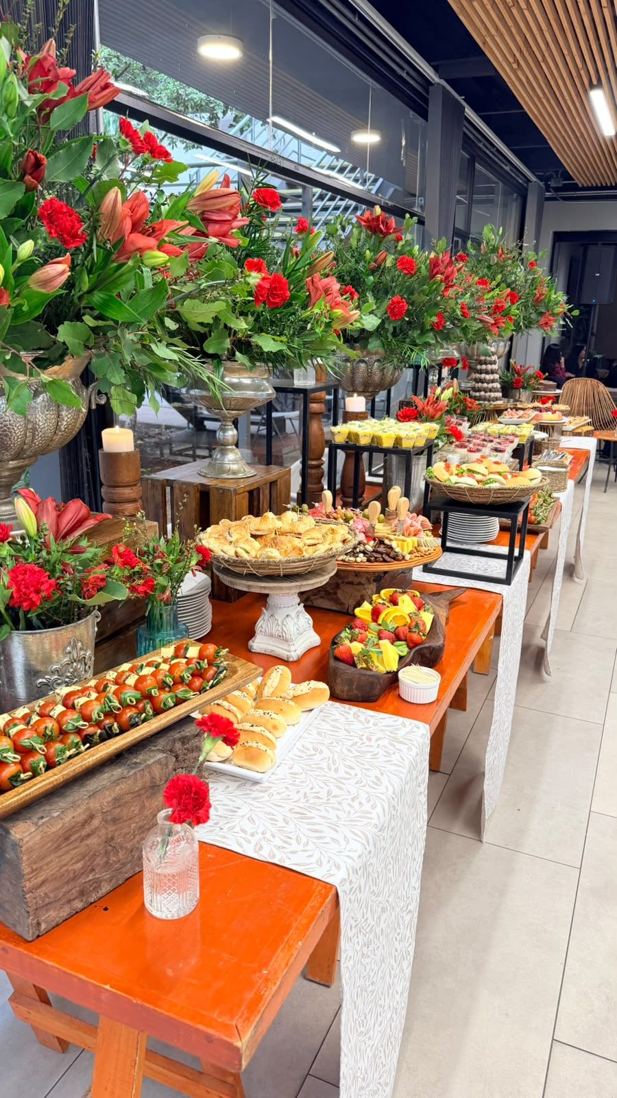 Pasillo de buffet con flores rojas, velas y bocados