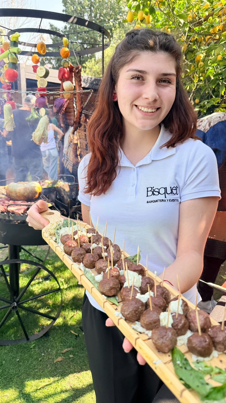 Garzona del equipo Bisquet con tabla de brochetas de carne