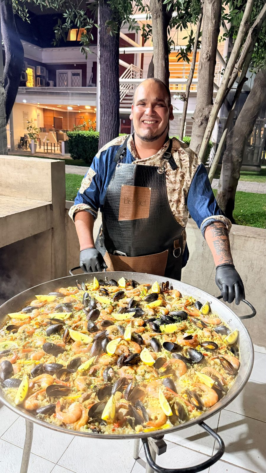 Paellero de Bisquet junto a una paella recién hecha