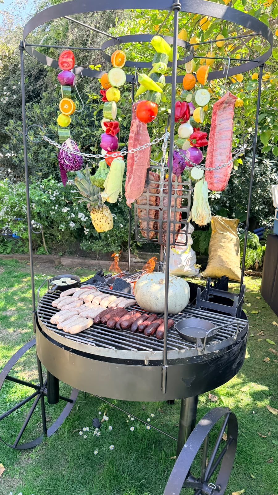 Parrilla circular con verduras, frutas y cortes colgantes