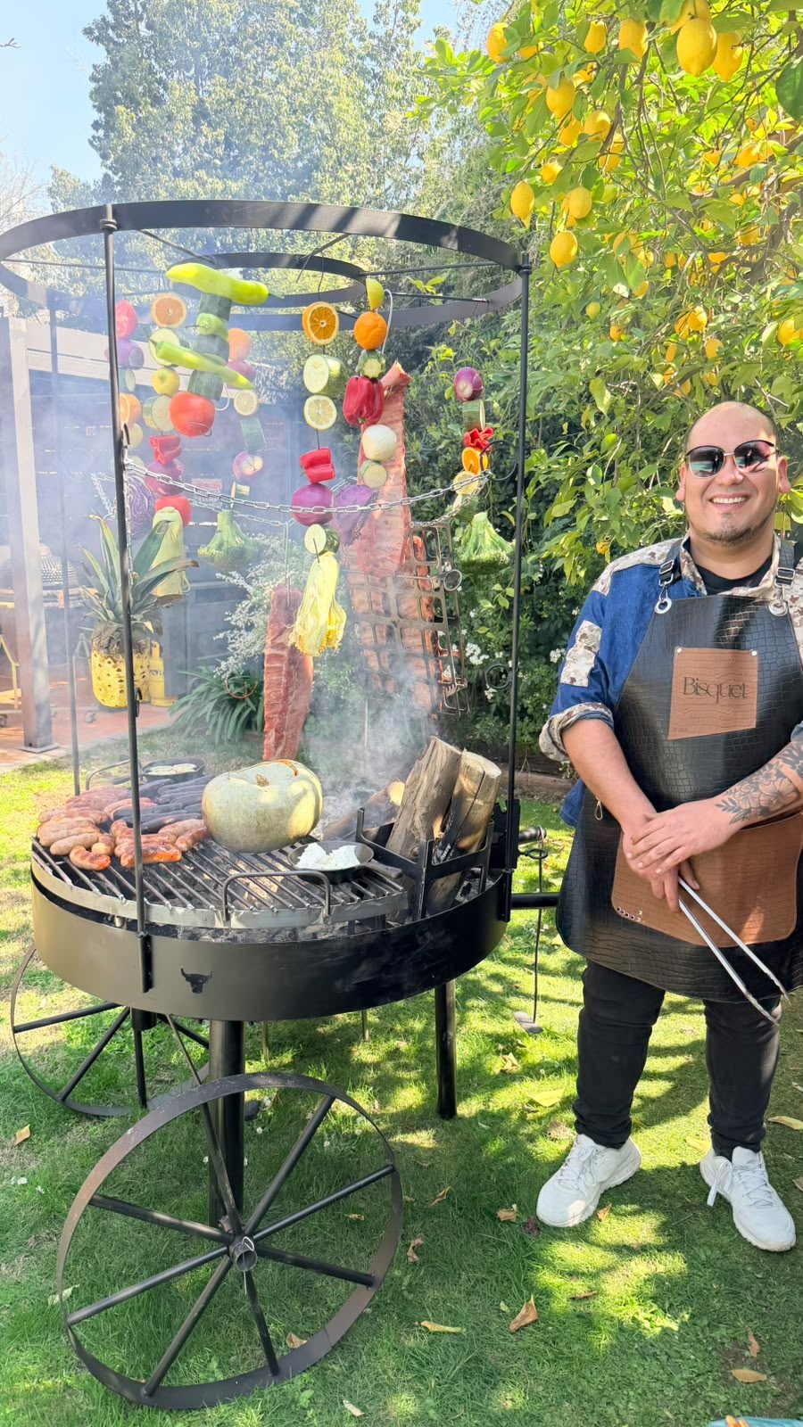 Parrillero junto a la parrilla colgante en un jardín