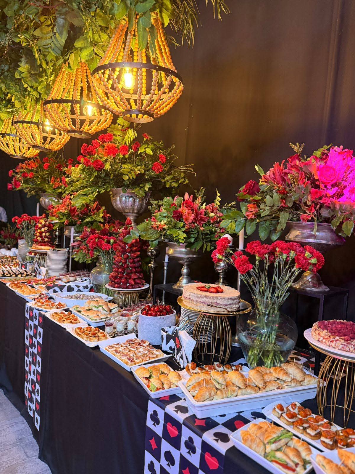 Buffet decorado con arreglos florales rojos y candelabros