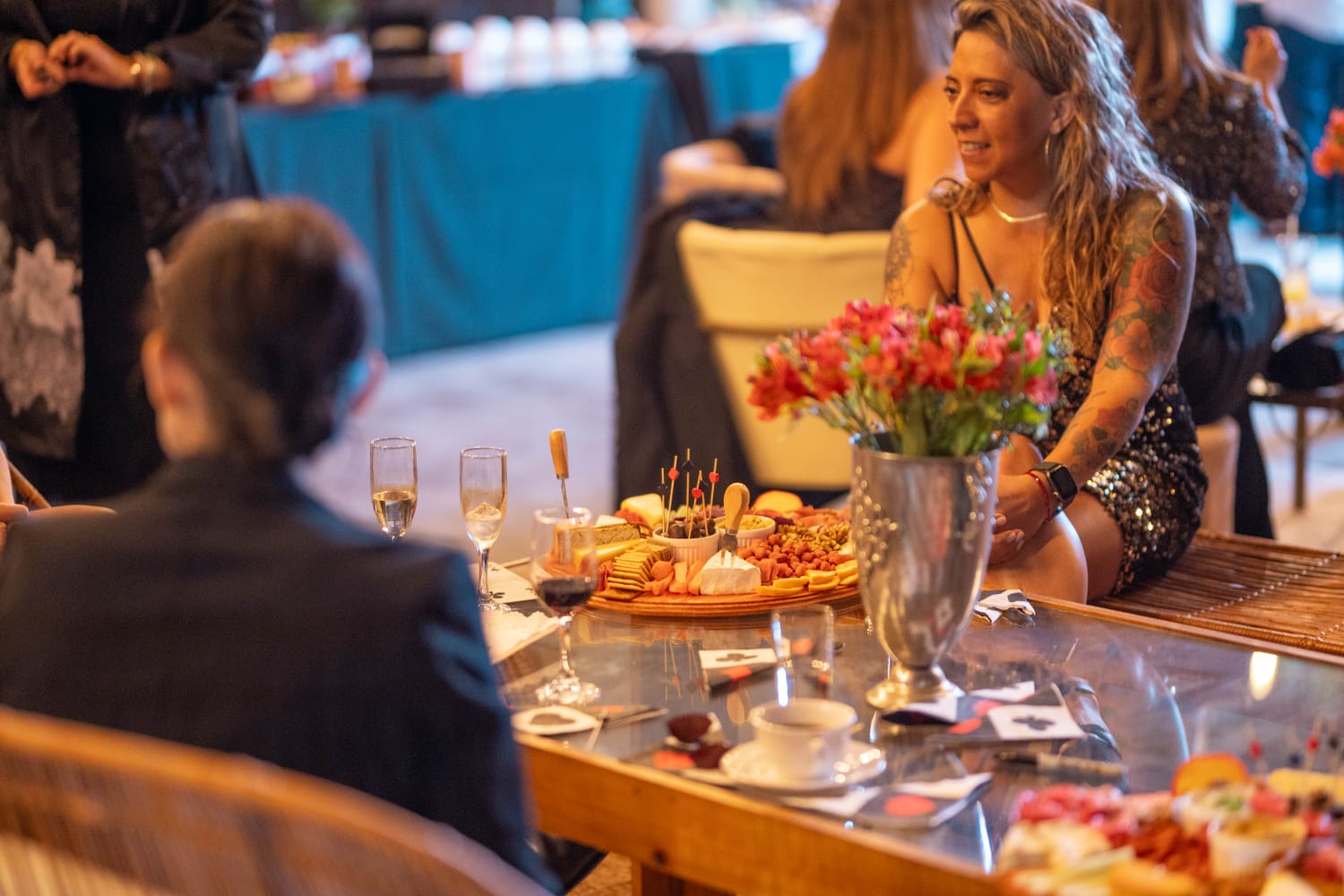 Invitados compartiendo alrededor de una tabla de quesos