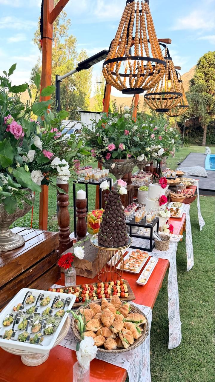 Mesa de buffet junto a la piscina en un jardín