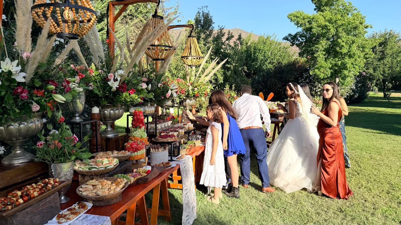 Novia junto a la mesa de buffet en un matrimonio de jardín