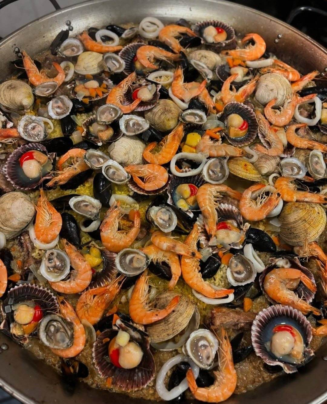 Paellera preparándose frente a los invitados